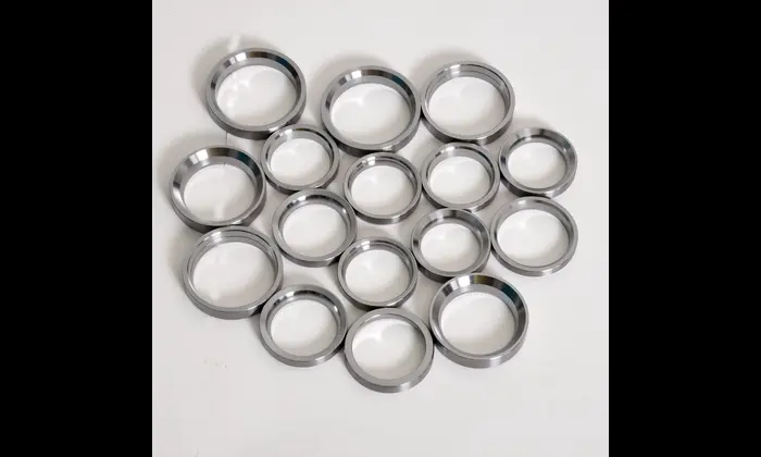 Precision-machined valve seat inserts arranged on a white background – high-performance engine components by JRB Engineering